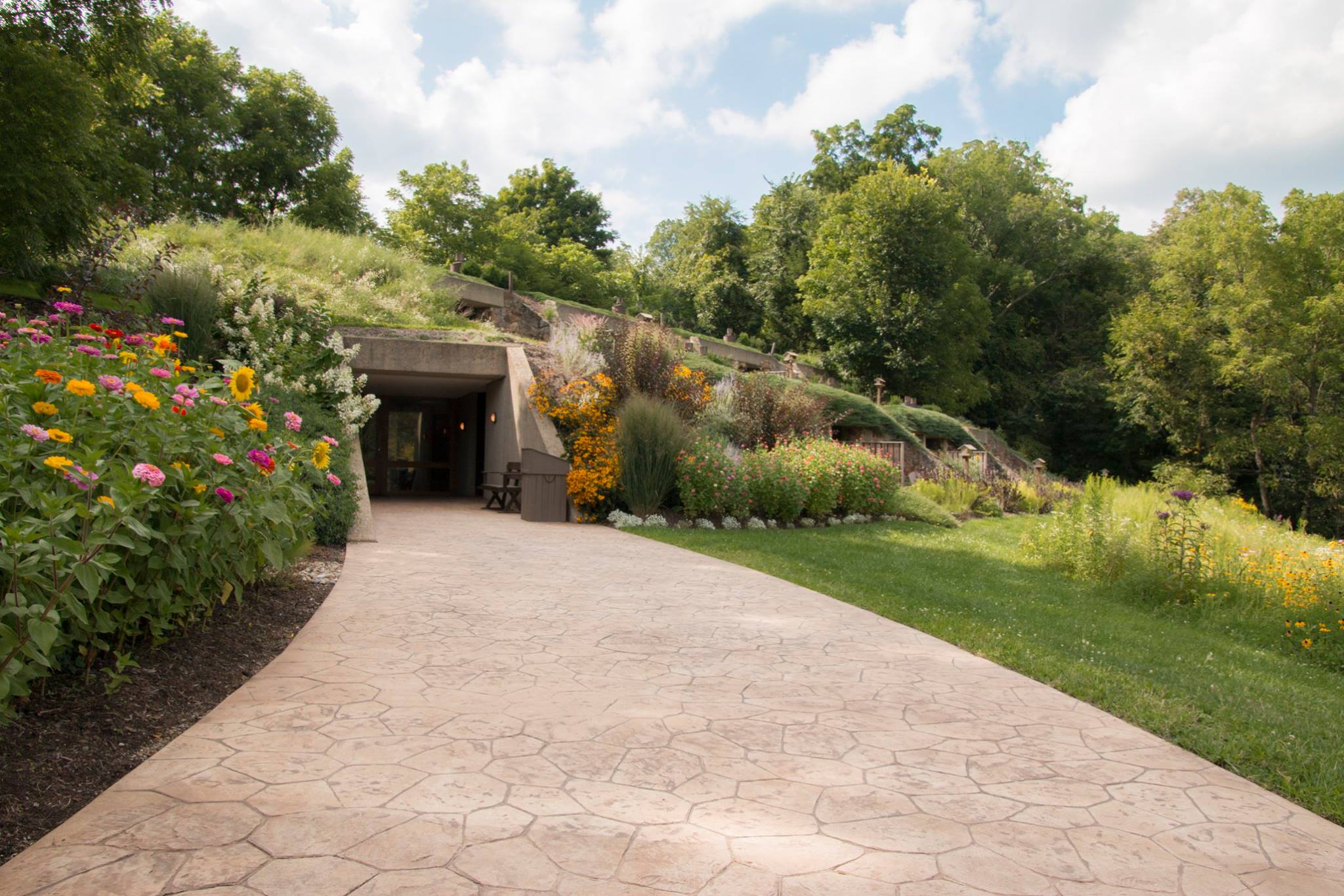 a hotel built into a hillside covered in flowers